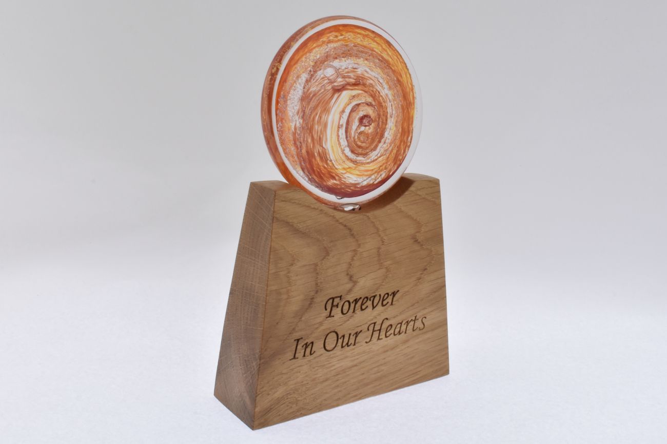Remembrance Glass Disk with Encased Ashes on Tapered Wooden Base.